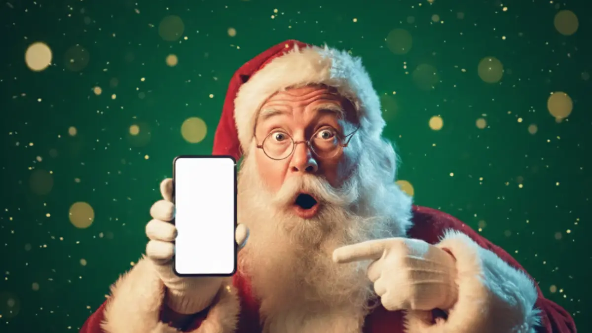 Père Noël montre smartphone en souriant, ravi des nouveaux forfaits de Syma avec appels vers l'international en bonus