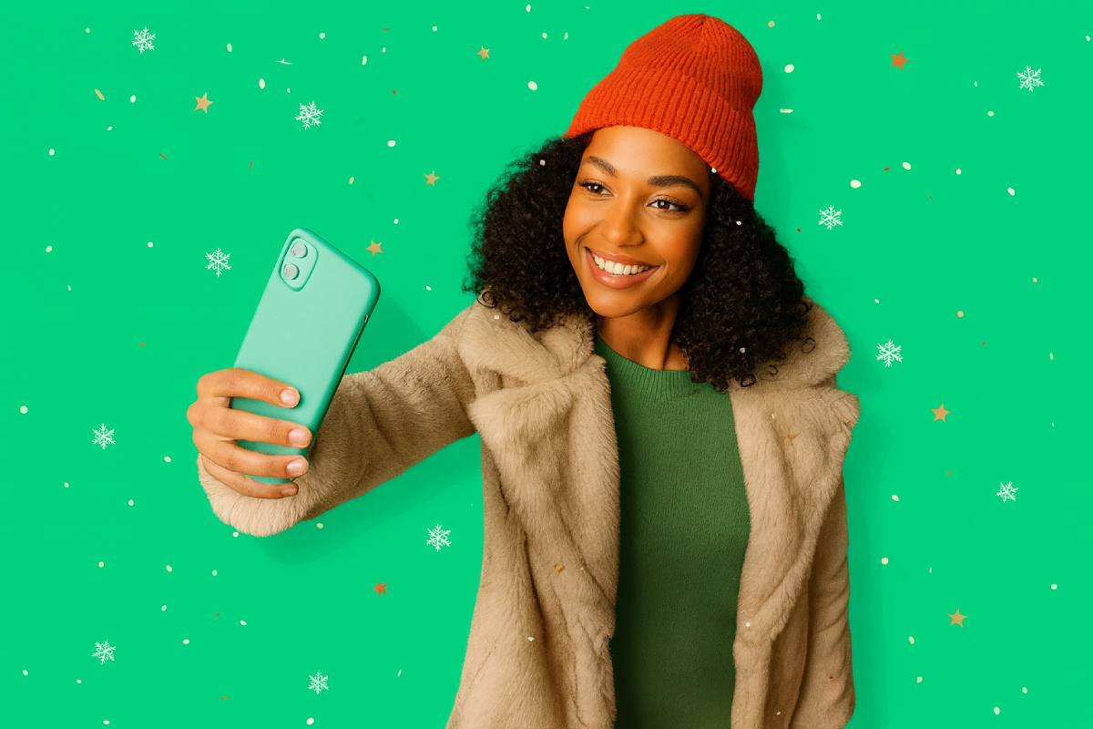 Femme contente avec bonnet de Noel et smartphone a la main