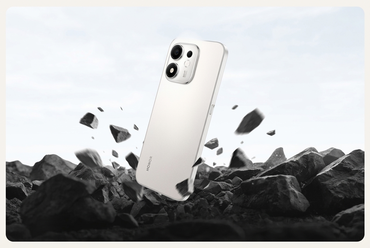 Smartphone Honor blanc positionné au-dessus de rochers noirs.