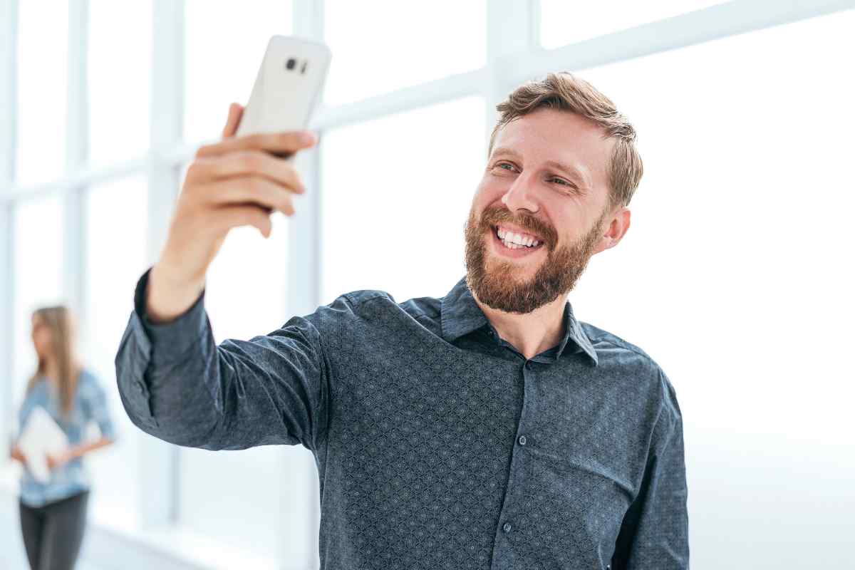 Homme heureux d'avoir acheter un smartphone reconditionné