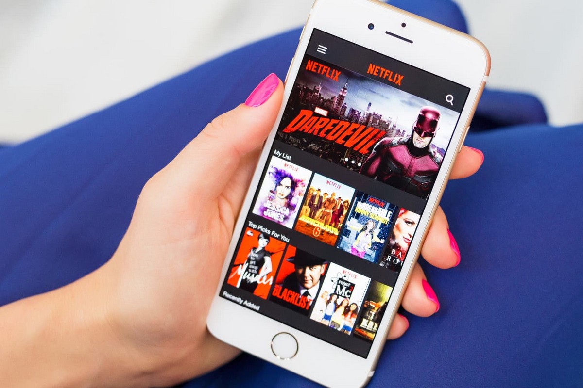 Smartphone dans la main avec Netflix, offert 6 mois avec forfait mobile d'Orange