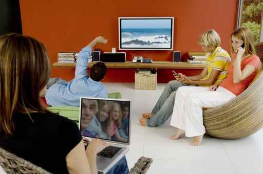 Familie în fața a 2 ecrane datorită TV-ului portocaliu gratuit