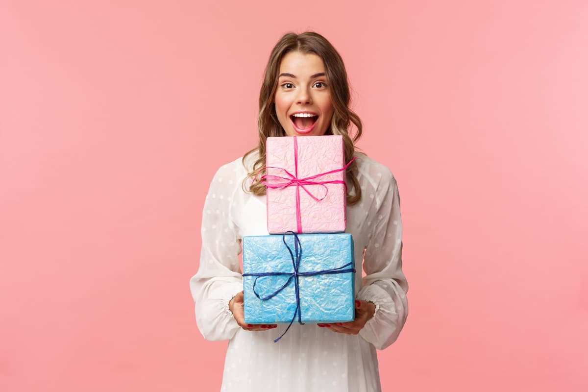 Fille avec 2 cadeaux dans les bras, car 2 mois offerts chez 3 opérateurs mobile du réseau SFR