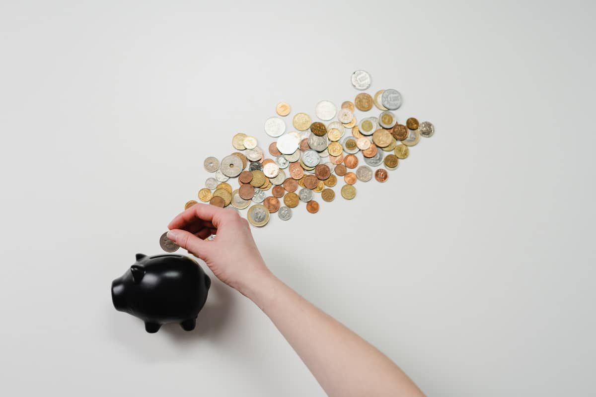 Main et pièce et tirelire cochon noire, car on fait des économies avec les forfaits flexibles de Pritel