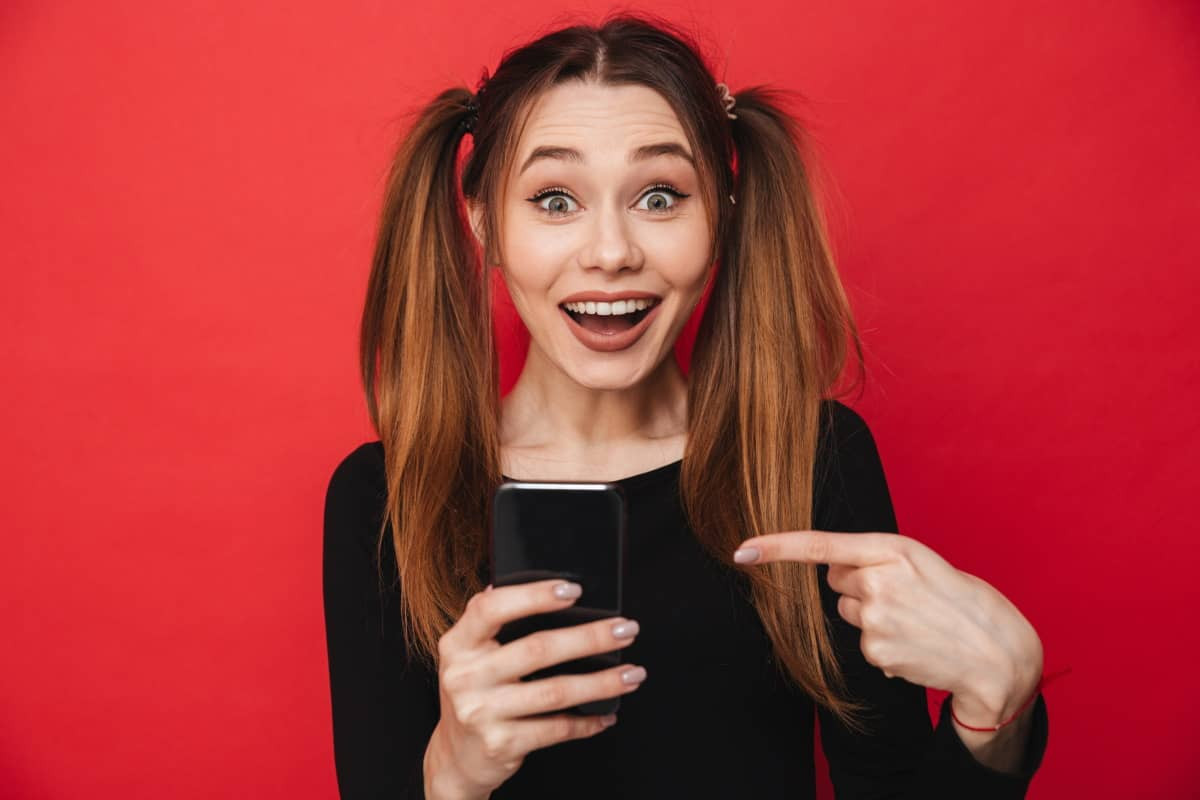 Femme avec couette ravie de son téléphone à prix mini grâce à la 5G Week de SFR