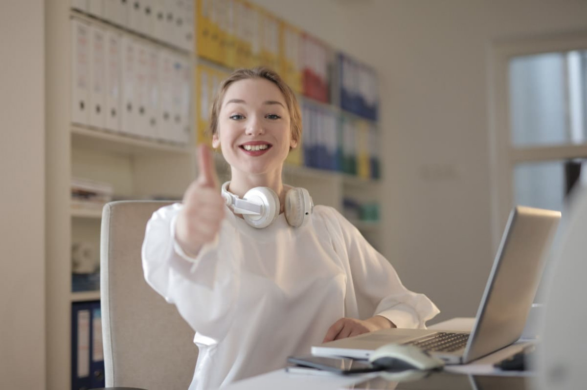 Fille devant PC montre pouce levé, car SFR élu meilleur service client 2024