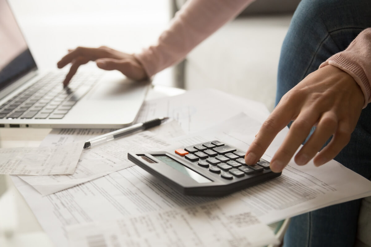 Calculatrice et PC portable sur bureau, pour calculer les économies des Box à prix fixe de SFR