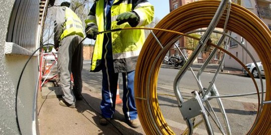 Des techniciens déploient la fibre optique dans une rue