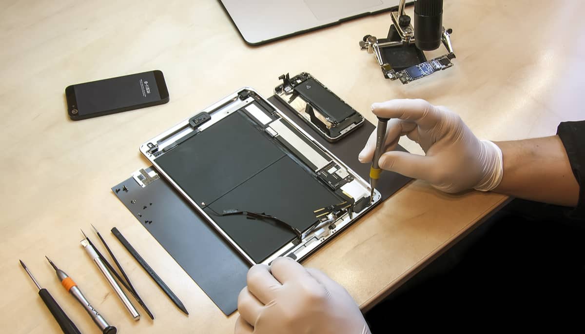 Un technicien remplace l'écran cassé d'une tablette
